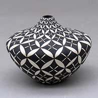 Click for a larger view A small black on white tear drop jar decorated with a pumpkin seed snowflake and geometric design
by Dorothy Torivio of Acoma