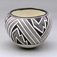 A small black on white jar decorated with a three panel fineline, lightning bolt and geometric design
 by Lucy Lewis of Acoma
