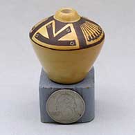 A miniature black on yellow high shouldered jar decorated above the shoulder with a four panel feather and geometric design
 by Les Namingha of Hopi