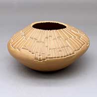 A buff jar with an organic opening and carved above the shoulder with a geometric design
 by Jody Folwell of Santa Clara