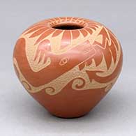 A red seed pot decorated with a sgraffito avanyu, feather and geometric design
 by Alfred Aguilar of San Ildefonso