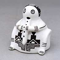 A black on white flute player figure decorated with a geometric design
 by Wanda Aragon of Acoma
