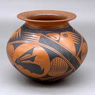 A black on red jar with a rolled lip and decorated with a three panel rabbit, hawk and geometric design
 by Roberto Banuelos of Mata Ortiz and Casas Grandes