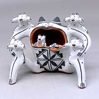 A polychrome frog storyteller figure with a fly on its tongue and five babies
 by Martha Arquero of Cochiti