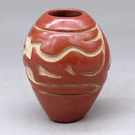A red jar carved with an avanyu and geometric design
 by Stella Chavarria of Santa Clara