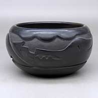 A black bowl carved with an avanyu and geometric design around the body
 by Mida Tafoya of Santa Clara