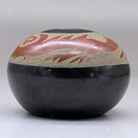 A black seed pot decorated with a sgraffito avanyu design in a wide band of sienna below the opening, click or tap to see a larger version
