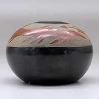 A black seed pot decorated with a sgraffito avanyu design in a wide band of sienna below the opening, click or tap to see a larger version