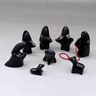 An eight piece black on black Nativity set with a string of red heishi beads
 by Autumn Borts of Santa Clara