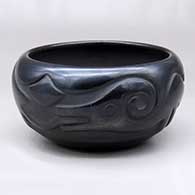 A black bowl carved with an avanyu and cloud design around the body
 by Rose Gonzales of San Ildefonso