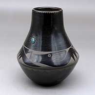 A black on black jar decorated with an avanyu, cloud, spider and geometric design, plus an inlaid stone
 by Helen Gutierrez of San Ildefonso