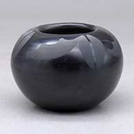 A small black on black bowl decorated above the shoulder with a four panel geometric design
 by Adam and Santana Martinez of San Ildefonso