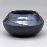 A small black on black bowl decorated above the shoulder with a two panel geometric design
 by Rose Gonzales of San Ildefonso