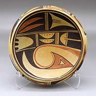 A shallow polychrome bowl decorated with a stylized bird-hanging-from-sky-band, bird element and geometric design inside, and a two-panel geometric design around the outside
 by Unknown of Hopi