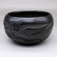 A black bowl carved around the body with an avanyu design
 by Christina Naranjo of Santa Clara