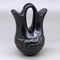 A small black wedding vase decorated with a carved stylized avanyu around the body
 by Jane Baca of Santa Clara