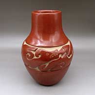A tall red jar carved with an avanyu and geometric design around the shoulder
 by Jennie Trammel of Santa Clara