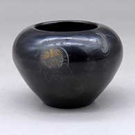 A small black bowl with a sienna spot and a sgraffito war shield, bear paw and geometric design
 by Kathy Sanchez of San Ildefonso