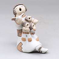 A grandmother holding a math book open and singing with the three children in her lap
 by Mona Teller of Isleta