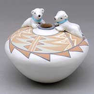 A polychrome seed pot decorated with a geometric design on top and a pair of polar bear appliques with heishi beads
 by Stella Teller of Isleta