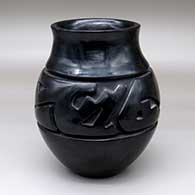 A polished black jar carved with a stylized avanyu design around the shoulder
 by Margaret Tafoya of Santa Clara
