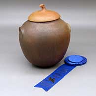 A lidded golden micaceous jar with fire clouds and inset shoulder handles, Ribbon is a Merit Award from the 2000 Lawrence Indian Arts Show, Lawrence, KS
 by Pam Lujan-Hauer of Taos