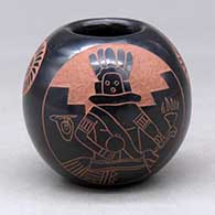 A black on red jar decorated with a sgraffito Pueblo dancer, sun face, feather and geometric design
 by Tom Tapia of Ohkay Owingeh