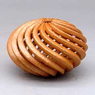A golden micaceous spiral carved melon jar with cutouts
 by Hubert Candelario of San Felipe