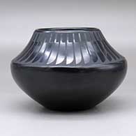 A black on black jar decorated with a band of feathers design above the shoulder, click or tap to see a larger version