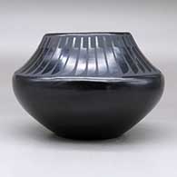 A black on black jar decorated with a band of feathers design above the shoulder, click or tap to see a larger version