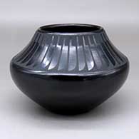 A black on black jar decorated with a band of feathers design above the shoulder
 by Maria Martinez of San Ildefonso