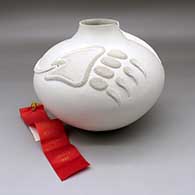 A white jar decorated with a bear paw and an ear of corn applique above the shoulder, Second Place ribbon 1988 Santa Fe Indian Market
 by Wilfred Garcia of Acoma
