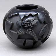 A small black bowl carved with a dragonfly, flower, leaf and geometric design
 by Autumn Borts of Santa Clara
