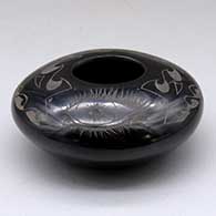 A black bowl decorated with a sgraffito eye and geometric design above the shoulder
 by Sergio Youngblood of Santa Clara