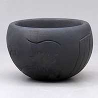 A black on black bowl decorated with a lightly carved and sgraffito animal and geometric design
 by Sergio Youngblood of Santa Clara