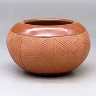 A matte and polished red Potsuwii-style bowl decorated with an eight-panel rock art and geometric design around the body
 by Rosita de Herrera of Ohkay Owingeh