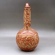 A large red wedding vase decorated with a sgraffito double avanyu, feather,bear paw and geometric design with inlaid stones and strands of heishi beads, click or tap to see a larger version