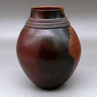 A brown jar decorated with a biyo around the neck and fire clouds
 by Samuel Manymules of Dineh
