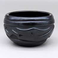 An open black bowl polished inside and carved with an avanyu design on the outside
 by Clara Shije of Santa Clara