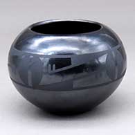 A matte black on gunmetal black bowl decorated with a four panel geometric design
 by Maria Martinez of San Ildefonso