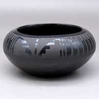 A black on black bowl decorated with a four-panel feather and geometric design above the shoulder
 by Marvin and Frances Martinez of San Ildefonso