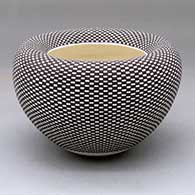 A black on white jar with an Infinity rim and decorated with a checkerboard geometric design
 by Frederica Antonio of Acoma