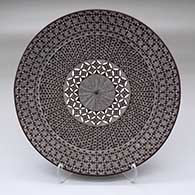 A black on white plate decorated with a North Star fineline and geometric design
 by Rebecca Lucario of Acoma