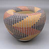 A polychrome jar with an infinity rim and decorated with a four-panel geometric design built of filling in tiny squares in a grid
 by Frederica Antonio of Acoma