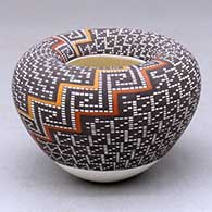 A small polychrome bowl with an Infinity rim and decorated with a two-panel tiny square geometric design
 by Frederica Antonio of Acoma