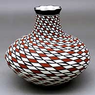 A polychrome low-shouldered jar with a pie crust rim and decorated with a spiraling stylized checkerboard geometric design
 by Paula Estevan of Acoma