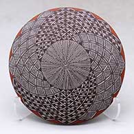 A polychrome seed pot decorated with a North Star fineline and geometric design above the shoulder
 by Rebecca Lucario of Acoma