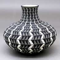 A black on white jar decorated with a lightning bolt, fineline and geometric design
 by Paula Estevan of Acoma