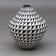 A black on white jar decorated with a spiral mesa geometric design
 by Cletus Victorino of Acoma