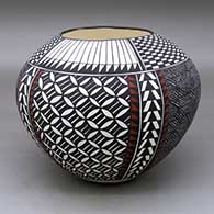 A polychrome jar decorated with a four-panel pumpkin seed snowflake, fineline, checkerboard, feather and geometric design
 by Sandra Victorino of Acoma